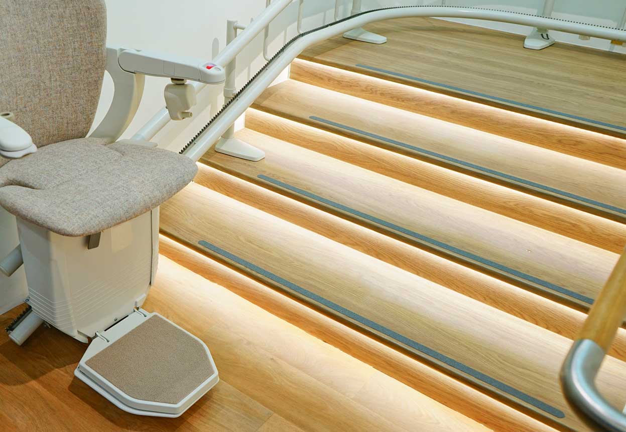 Escalier avec monte-escalier, bandes antidérapantes sur les marches et lumières LED