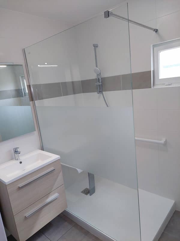 Salle de bain complète avec remplacement d’une baignoire en douche. Receveur antidérapant, mitigeur thermostatique, barre d’appui, siège escamotable, vasque PMR et WC surélevé.