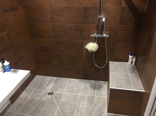 Modification d’une salle de bain pour PMR avec le remplacement de la baignoire en douche à l’italienne, la création d’un banc d’assise sur-mesure et d’une colonne de douche!